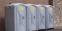 Grey portable toilets with Northland Septic Maintenance logo