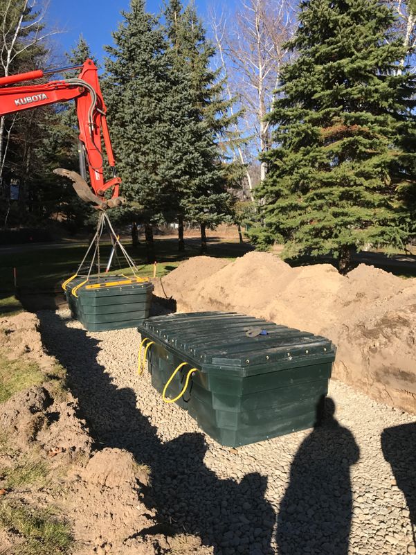 Crane lifting green tanks out of the ground