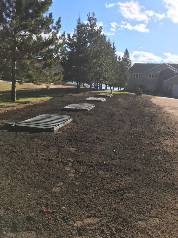 Field of dark dirt with exposed septic covers