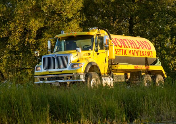 Northland Septic Maintenance truck reflected in a nearby lake