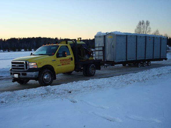 Northland truck transporting several portable toilets