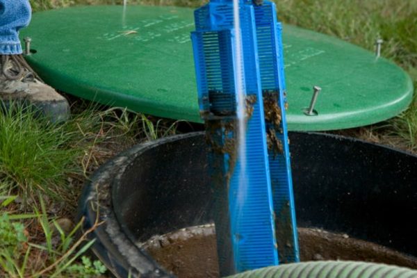 Washing septic tank components with a water hose and sprayer