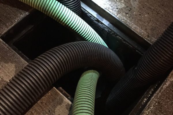 Five hoses in a drain hole in concrete