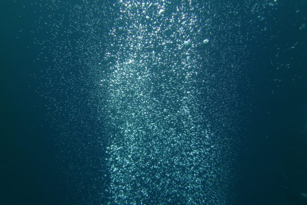 shutterstock_1341766418 Underwater bubbles rising from the depth of the blue sea